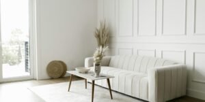Elegant and simple living room featuring minimalist furniture, a white sofa, and decor elements.